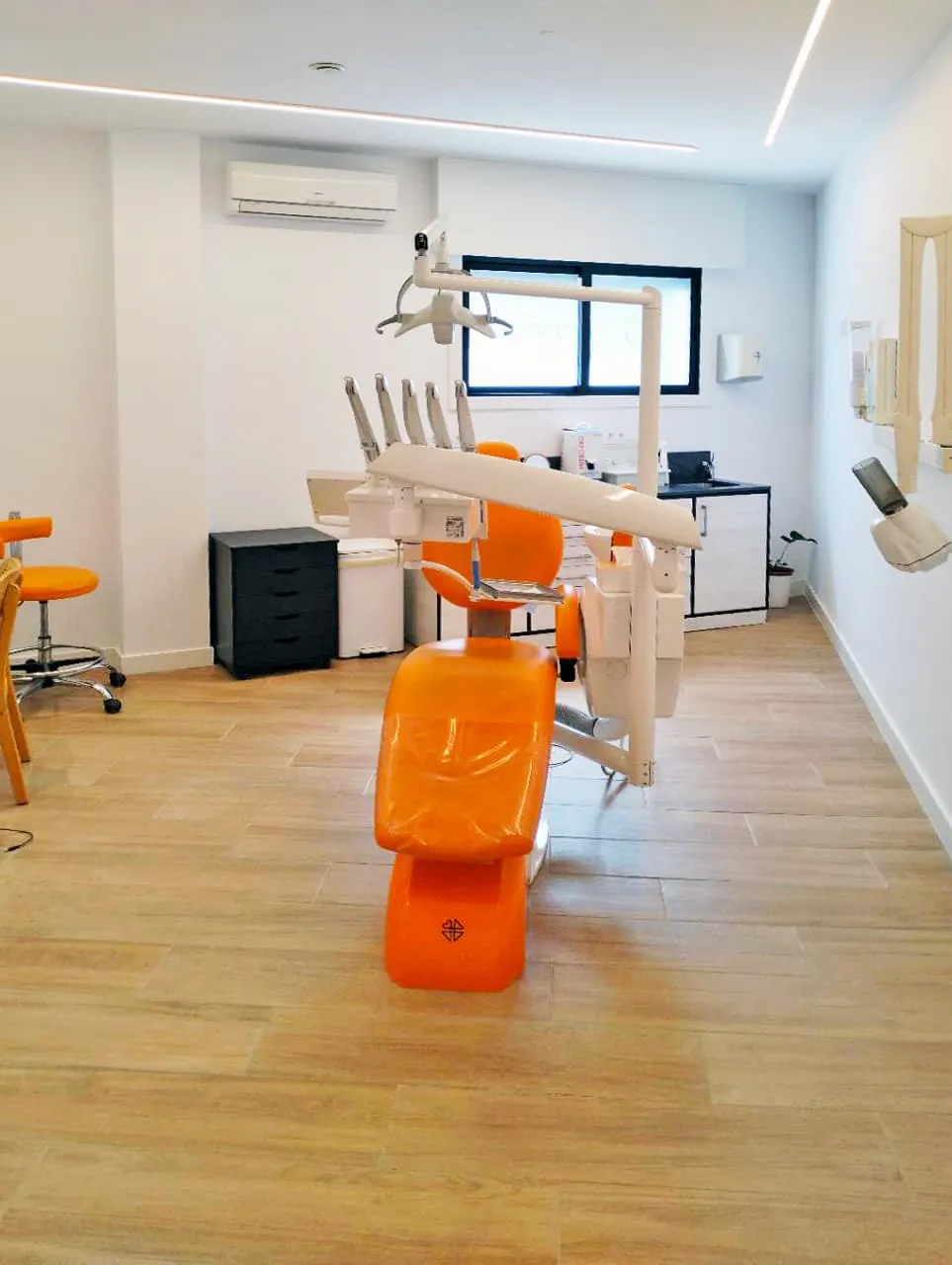 Gabinete de odontología general de Asoden Clínica Dental, con sillón naranja e instrumental