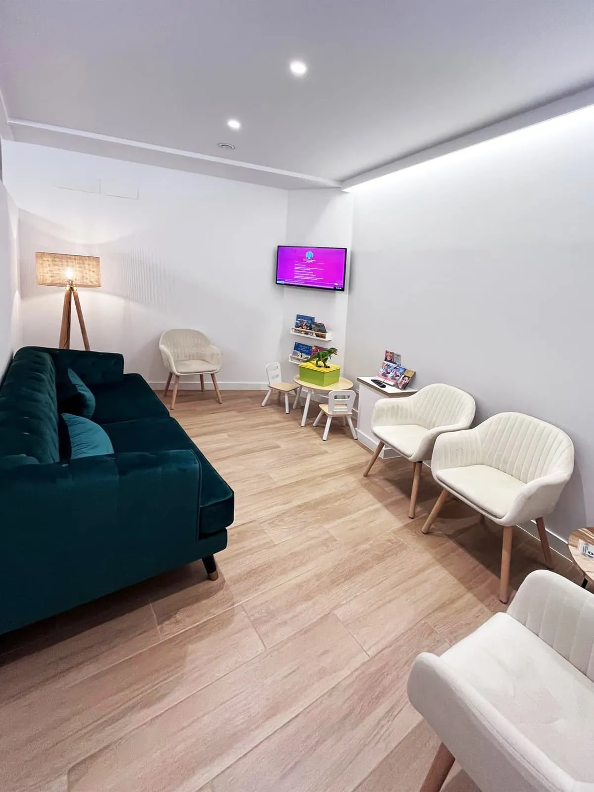 Sala de espera de Asoden Clínica Dental con sofá verde y zona infantil para niños